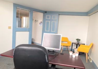 A large private office at FOCUS Coworking with a desk, computer, and visitor chairs.