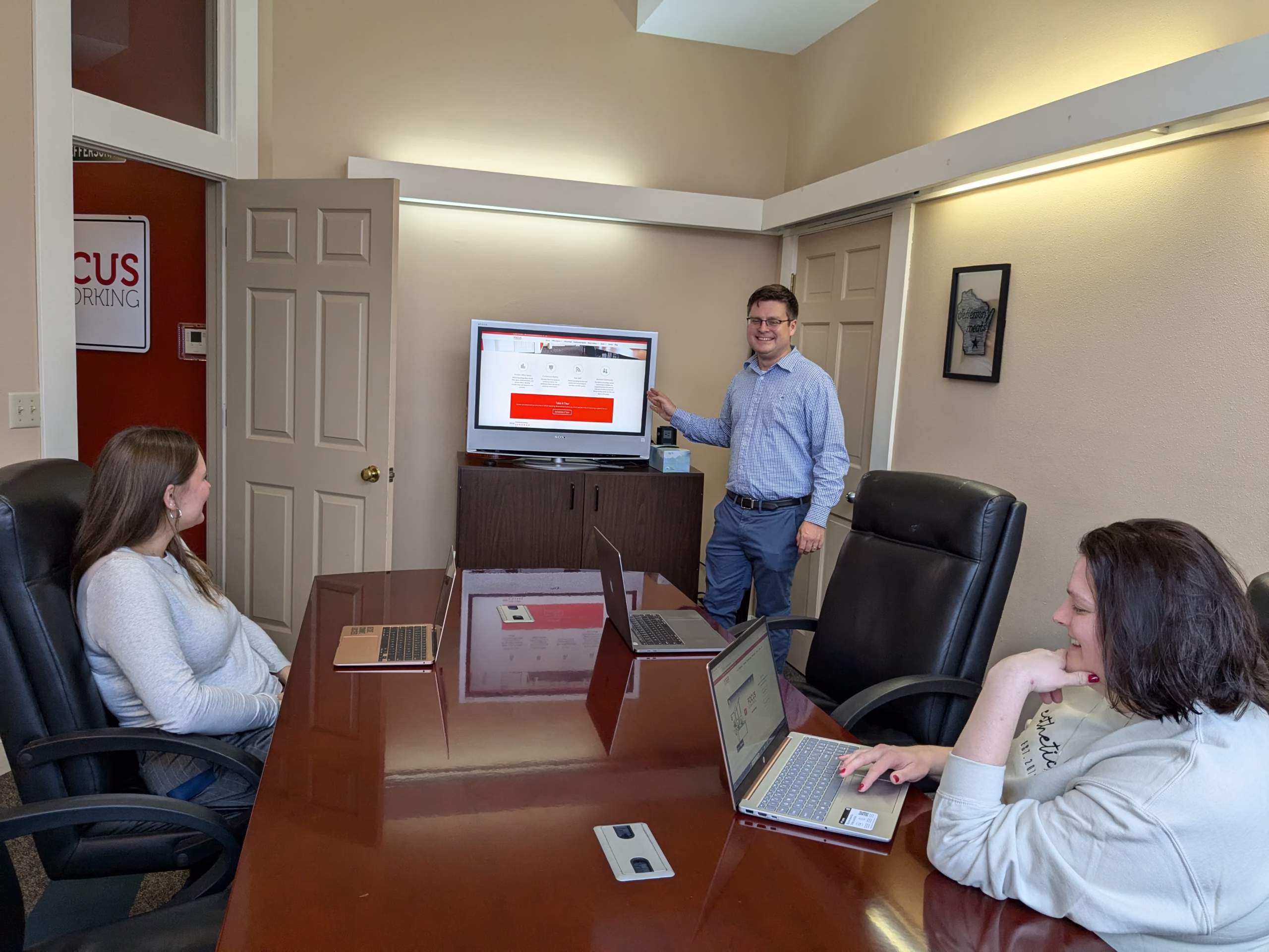 Damon presenting at the screen in the conference room.